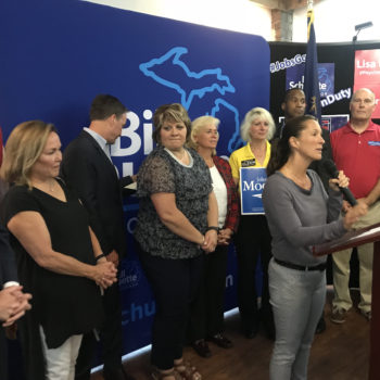 Group of people standing at a podium.